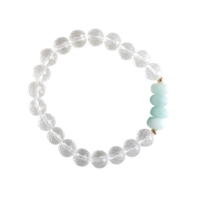 Close up image on a white background of a stretchy Amazonite and Clear Quartz mala bracelet. The bracelet has four faceted roundel beads made of Amazonite. The rest of the bracelet is made with 8mm faceted round Clear Quartz beads. Two small 2mm gold filled beads flank the Amazonite beads to separate them from the Clear Quartz.
