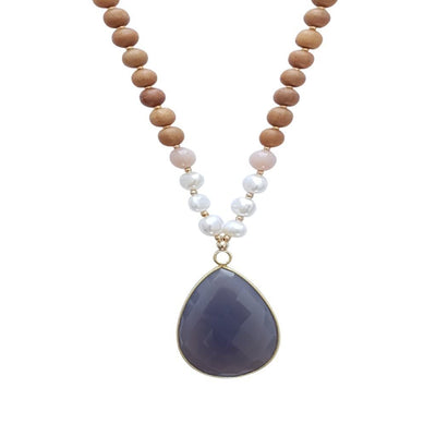 Close up image on a white background of a mala necklace with a 22x30mm faceted teardrop shaped Grey Moonstone guru stone edged with gold . On each side above the guru stone are three pearl beads and one pink moonstone bead. The rest of the mala necklace is made with 6mm sandalwood beads separated by 2mm gold spacer beads.